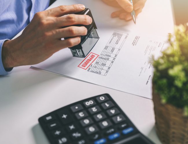 businessman accepting and stamping procurement bill in office